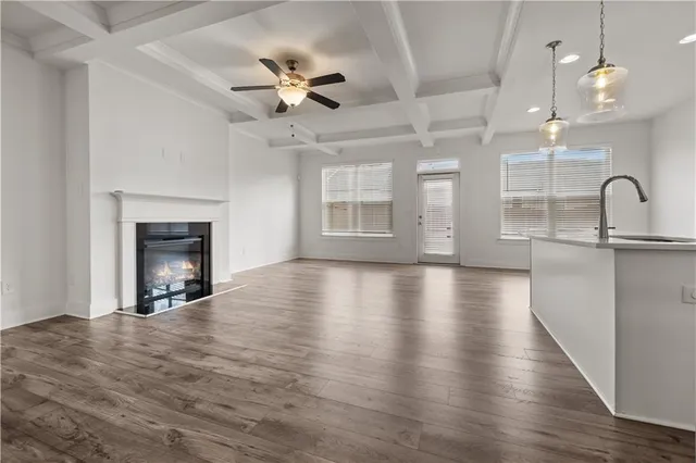 a view of a livingroom with a fireplace a chandelier and wooden floor