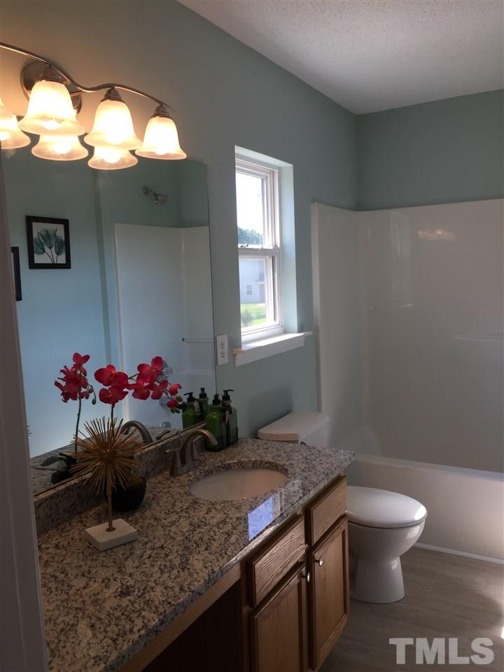 3800 Tryon Ridge Drive Raleigh, NC 27610 - Photo 14 of 18 a bathroom with a granite countertop sink a toilet and a mirror