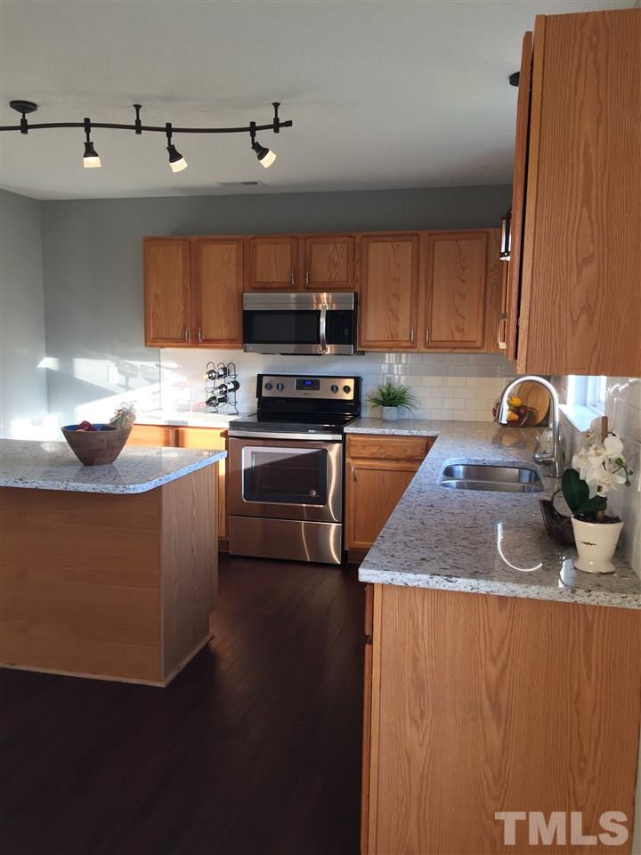 3800 Tryon Ridge Drive Raleigh, NC 27610 - Photo 3 of 18 a kitchen with stainless steel appliances granite countertop a sink a stove and a refrigerator