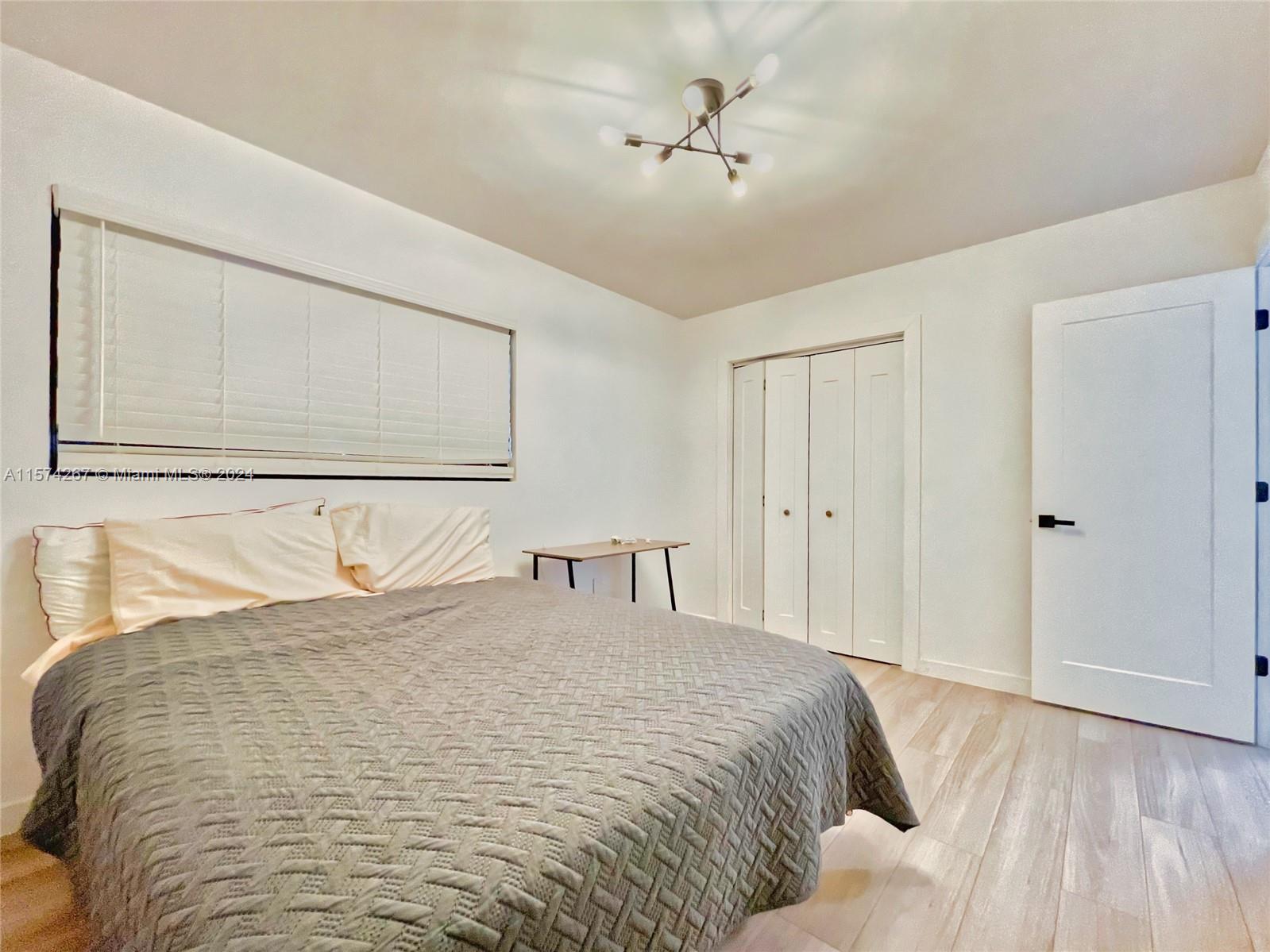 7040 Southwest 17th Terrace Miami, FL 33155 - Photo 15 of 26 a bedroom with a bed and a chandelier