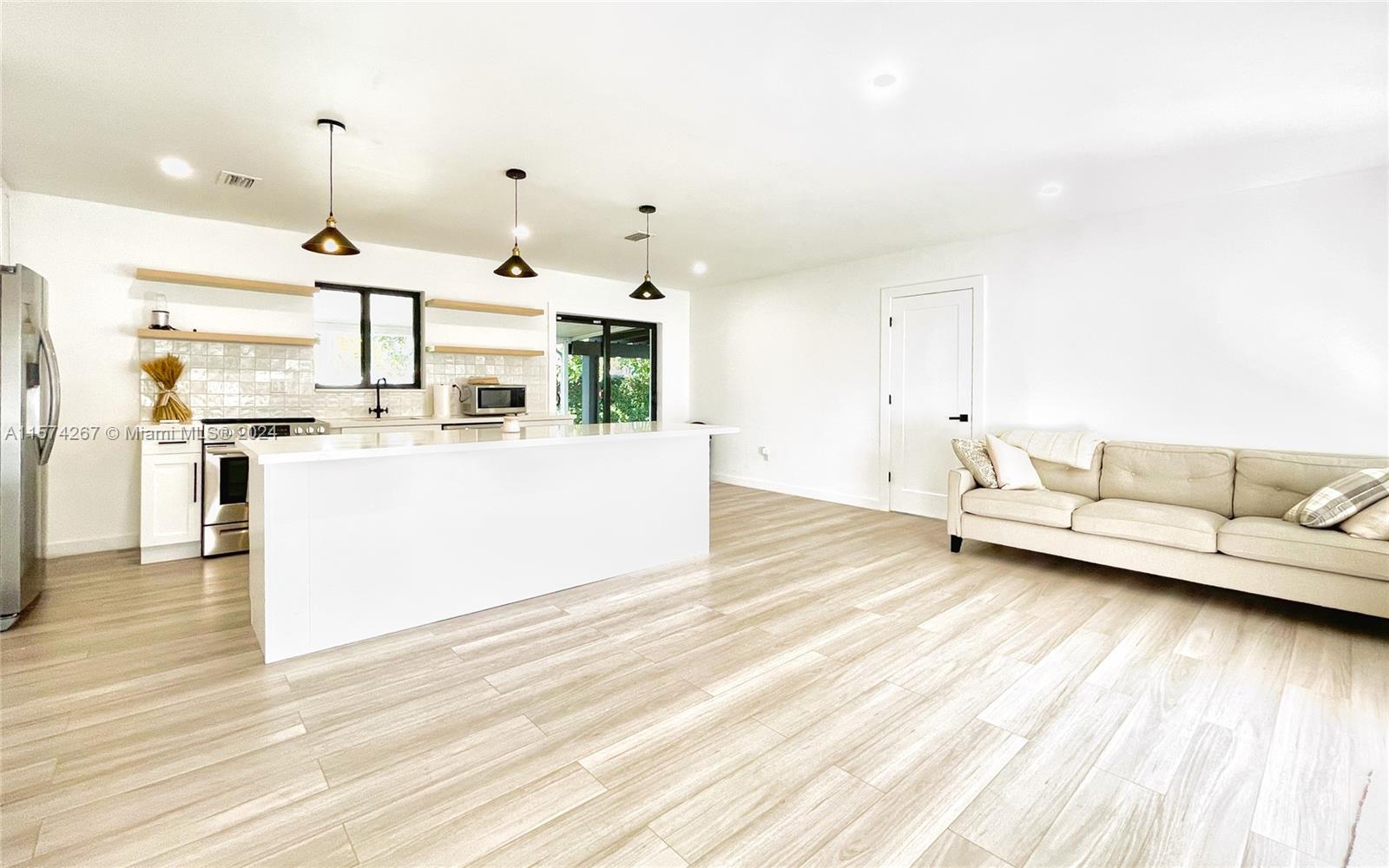 7040 Southwest 17th Terrace Miami, FL 33155 - Photo 5 of 26 a living room with kitchen island furniture and a chandelier