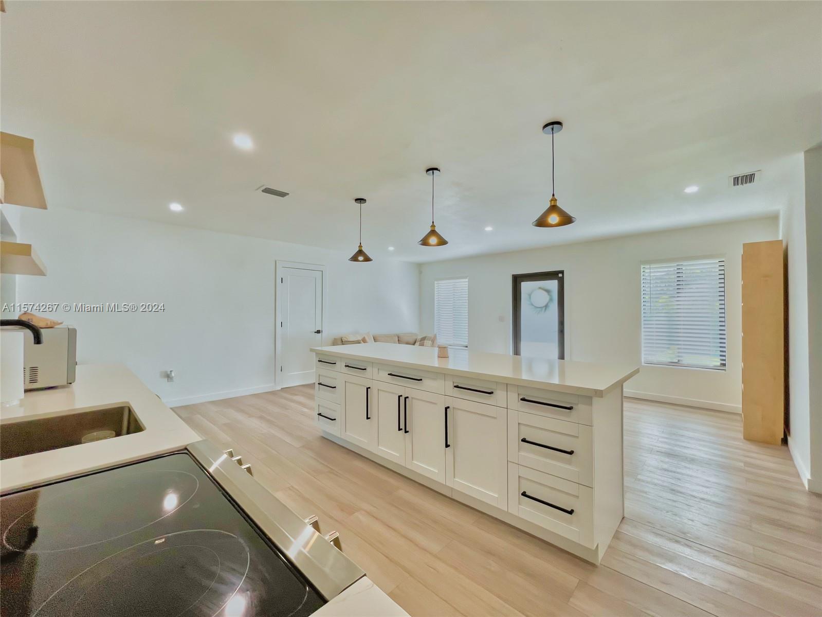 7040 Southwest 17th Terrace Miami, FL 33155 - Photo 6 of 26 a view of a kitchen with kitchen island a sink wooden floor and living room view