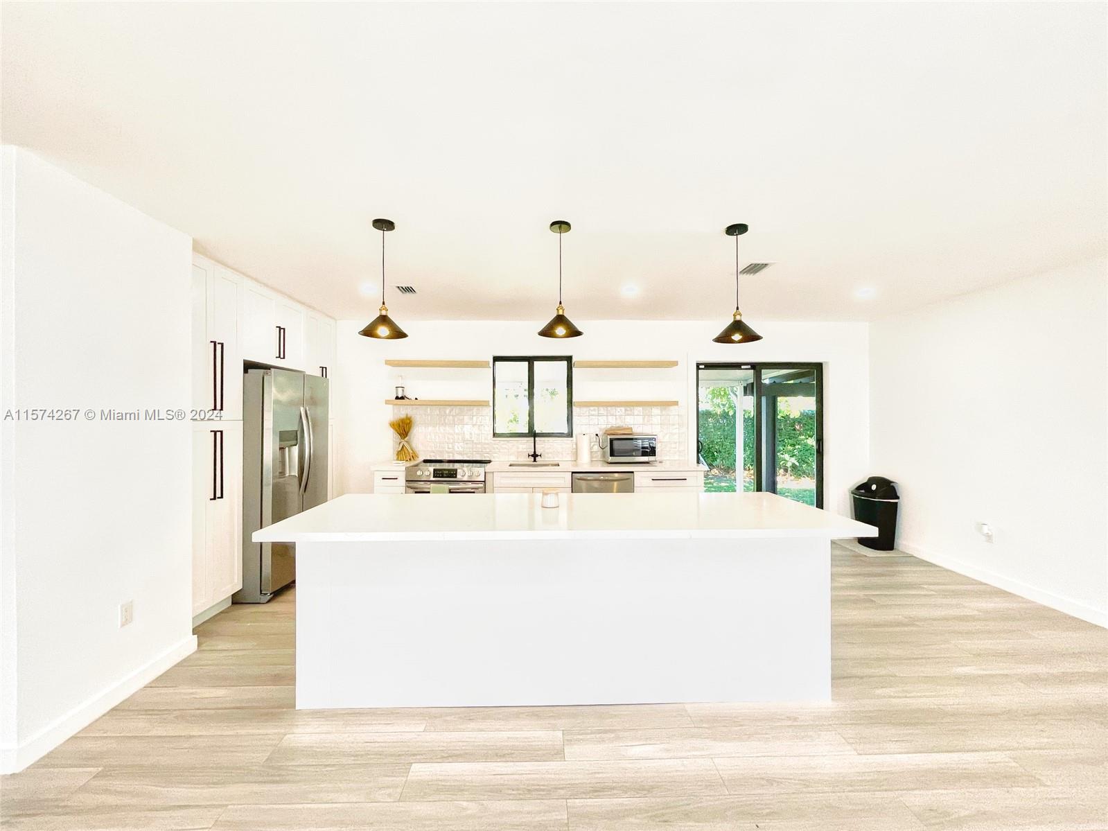 7040 Southwest 17th Terrace Miami, FL 33155 - Photo 7 of 26 a large white kitchen with wooden floor