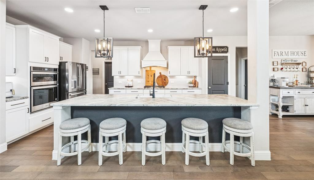 11852 Toppell Trail Fort Worth, TX 76052 - Photo 11 of 32 a kitchen with granite countertop a dining table chairs stainless steel appliances and wooden floor