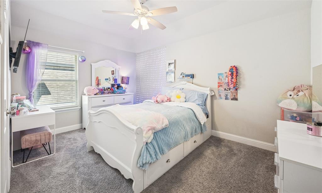 11852 Toppell Trail Fort Worth, TX 76052 - Photo 21 of 32 a bedroom with a bed and a chandelier