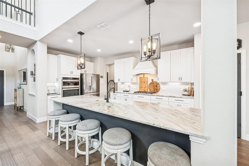 11852 Toppell Trail Fort Worth, TX 76052 - Photo 10 of 32 a kitchen with stainless steel appliances a dining table chairs and wooden floor