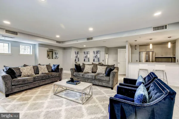 a living room with furniture a flat screen tv and kitchen view