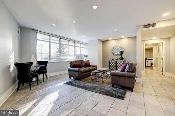 a living room with a large window and furniture