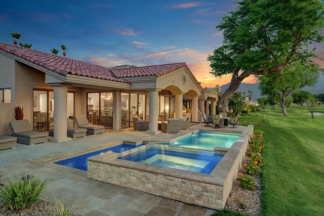 a front view of a house with swimming pool table and chairs