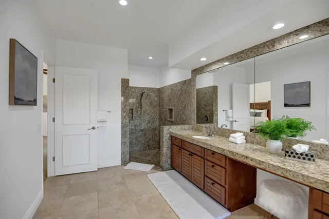a spacious bathroom with a granite countertop double vanity sink mirror and shower