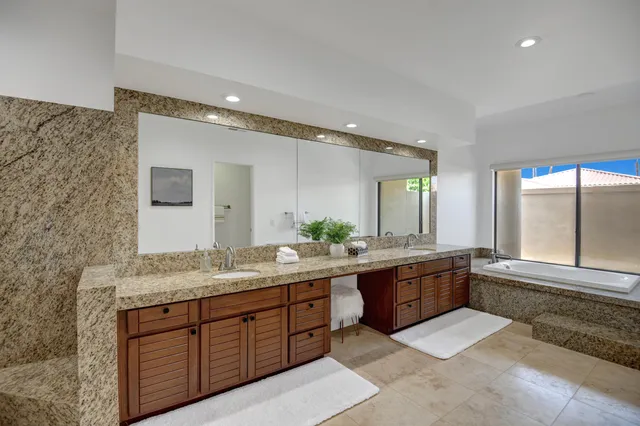 a large bathroom with double vanity and a large mirror