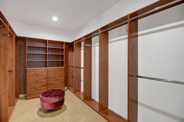 a view of walk in closet with clothes and shoes