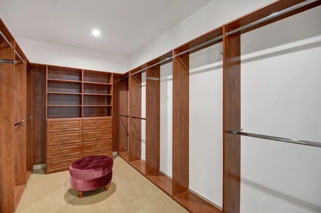 a view of walk in closet with clothes and shoes