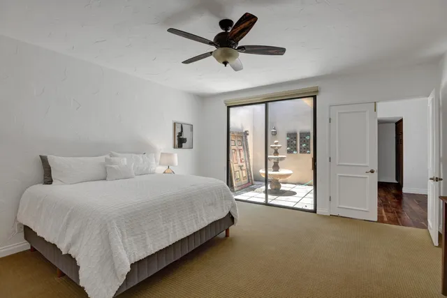 a bedroom with a large bed and a ceiling fan