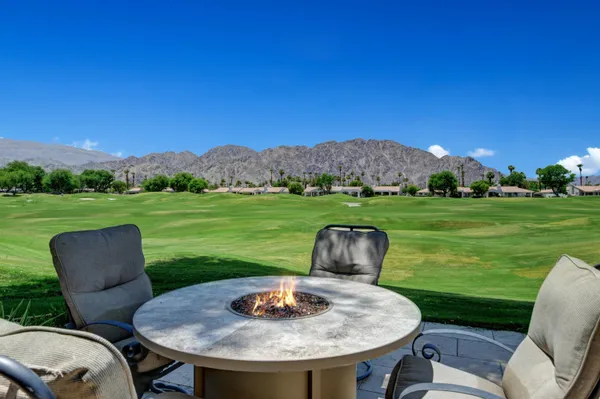a view of a chairs and table in the patio and a yard