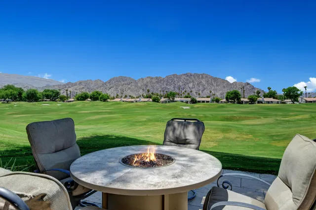 a view of a chairs and table in the patio and a yard