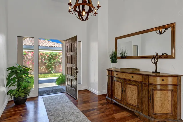 a view of a hallway with wooden floor and a potted plant