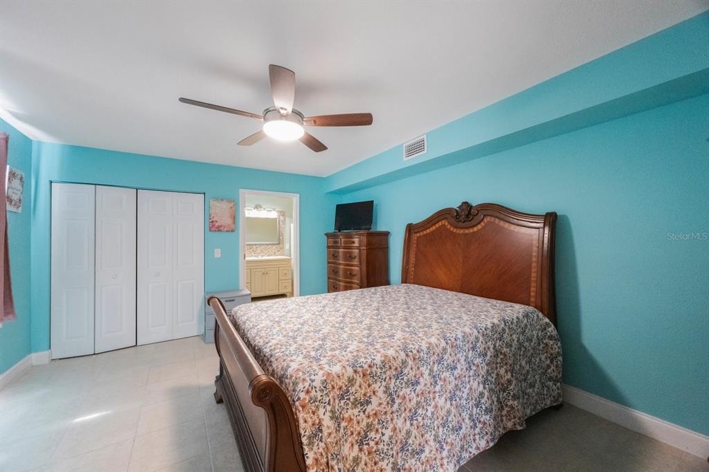 3336 20th Avenue Southwest Largo, FL 33774 - Photo 14 of 37 a bedroom with a large bed and a chandelier