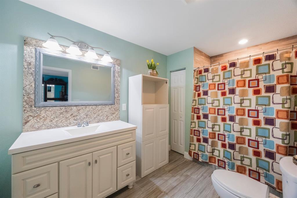 3336 20th Avenue Southwest Largo, FL 33774 - Photo 17 of 37 a bathroom with a sink a toilet a shower and a mirror