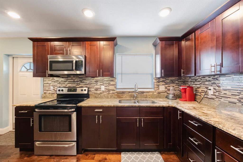3336 20th Avenue Southwest Largo, FL 33774 - Photo 8 of 37 a kitchen with stainless steel appliances granite countertop a stove a sink and a microwave