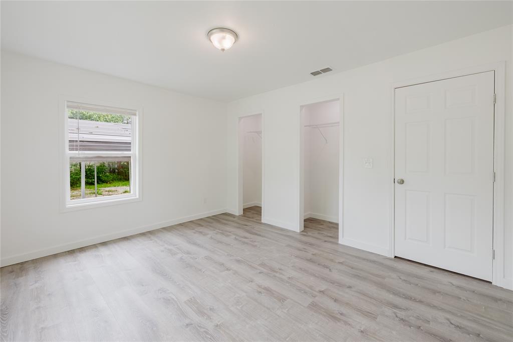 524 West Roberts Street Gorman, TX 76454 - Photo 17 of 35 an empty room with wooden floor and windows