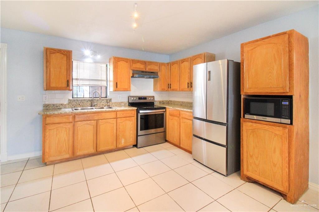 2921 Yuma Avenue McAllen, TX 78503 - Photo 5 of 10 a kitchen with stainless steel appliances granite countertop a stove a sink and a refrigerator
