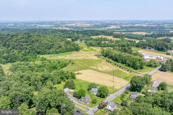 an aerial view of residential houses with outdoor space and trees