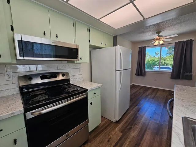 a view of an empty room with wooden floor and closet