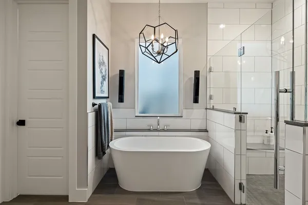 a large white bed in a bathroom next to a window