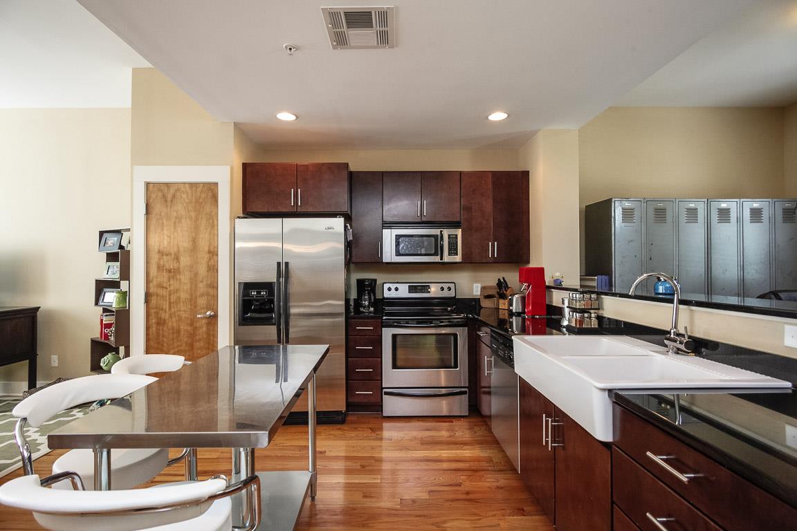 508 Madison Street, Unit 2 Nashville, TN 37208 - Photo 9 of 25 a kitchen with stainless steel appliances a stove a sink a microwave a refrigerator and chairs
