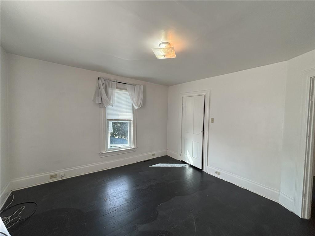 213 Franklin Street, Unit 2 Ligonier, PA 15658 - Photo 14 of 27 an empty room with a window and wooden floor