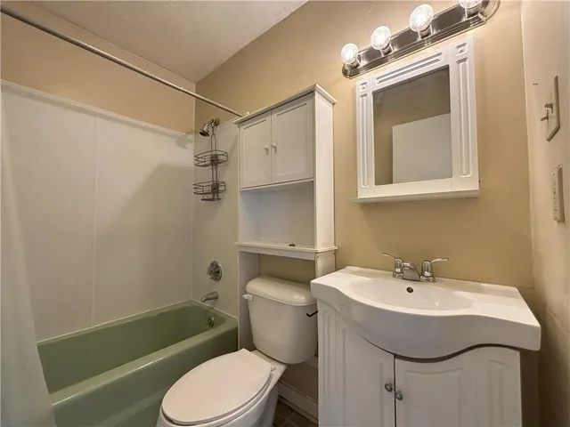 a bathroom with a sink a mirror toilet and bathtub