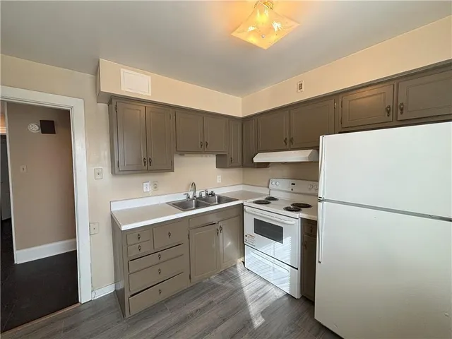 a kitchen with a sink a refrigerator and a stove