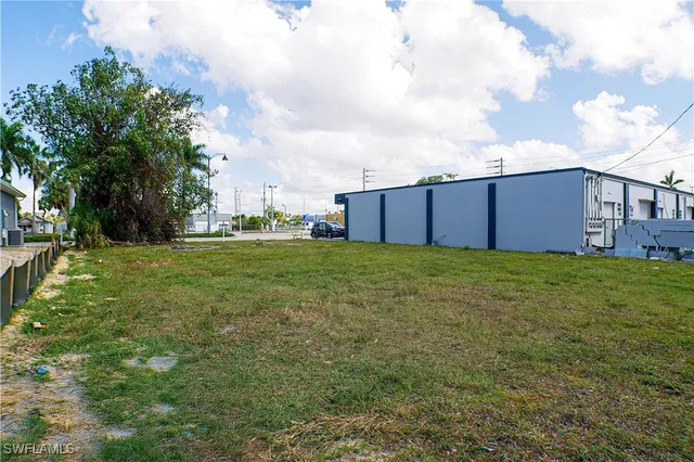 a view of a house with a big yard and large trees