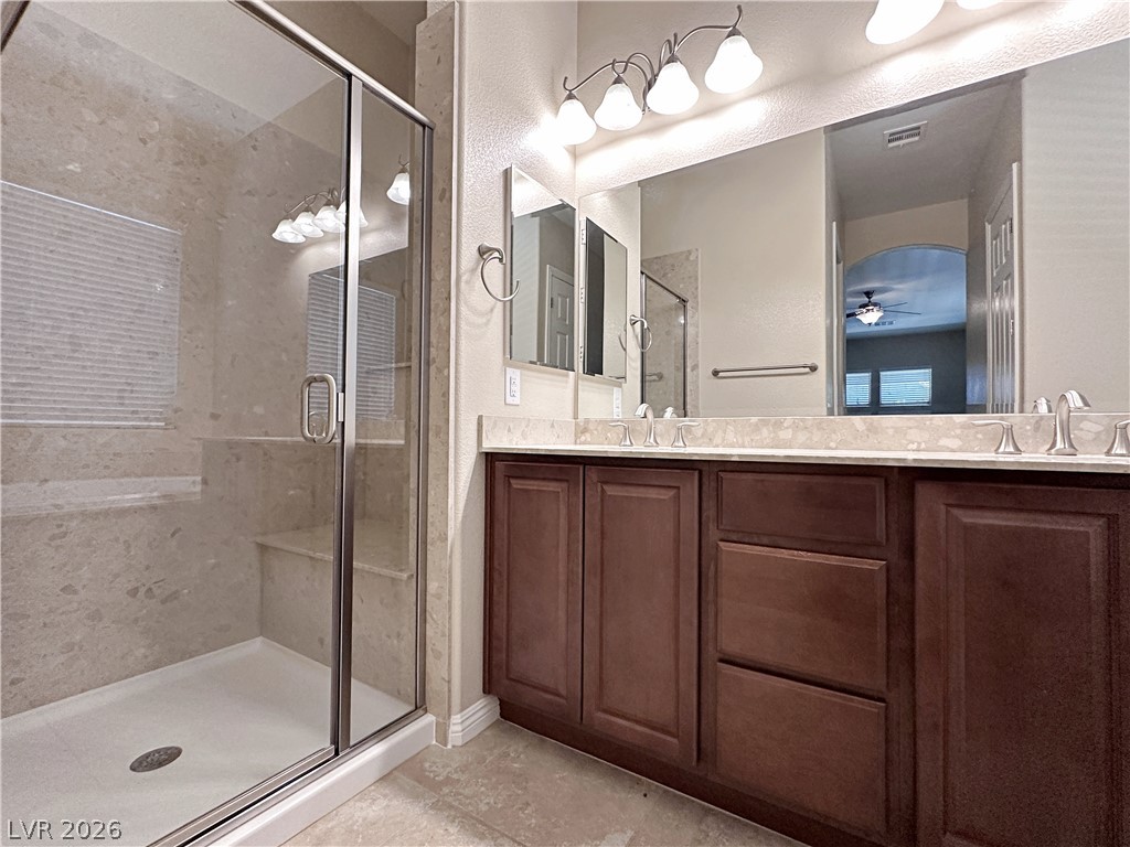 71 Newton Ridge Way Las Vegas, NV 89183 - Photo 32 of 40 Double vanity and a spacious glass-enclosed shower create a practical bathroom retreat.