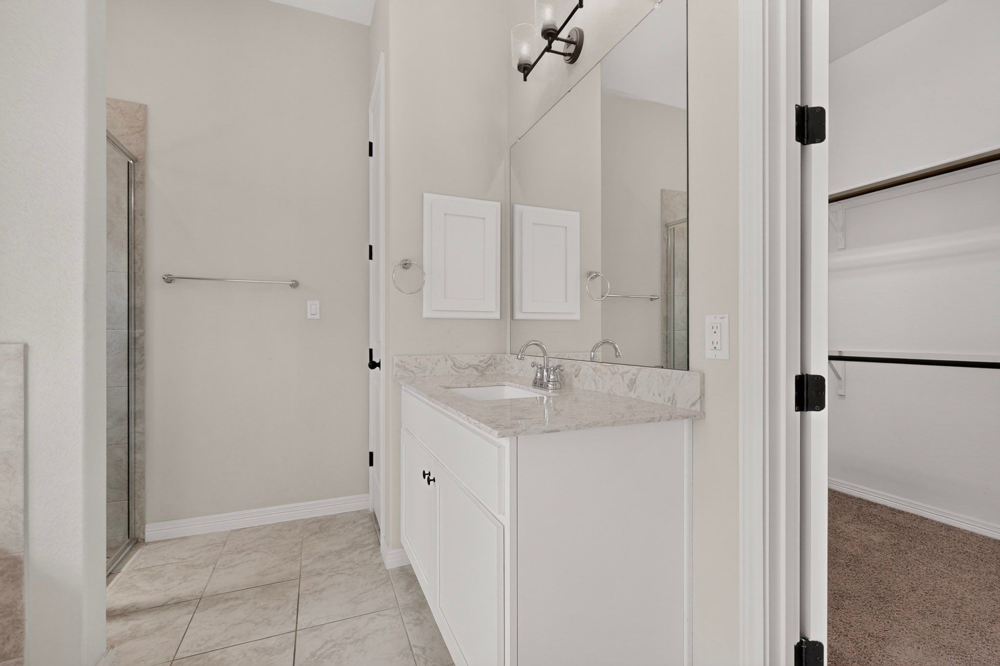 2433 La Mirada Street Leander, TX 78641 - Photo 9 of 25 A well-appointed bath features a sleek single vanity and glass-enclosed shower, offering comfort and style.