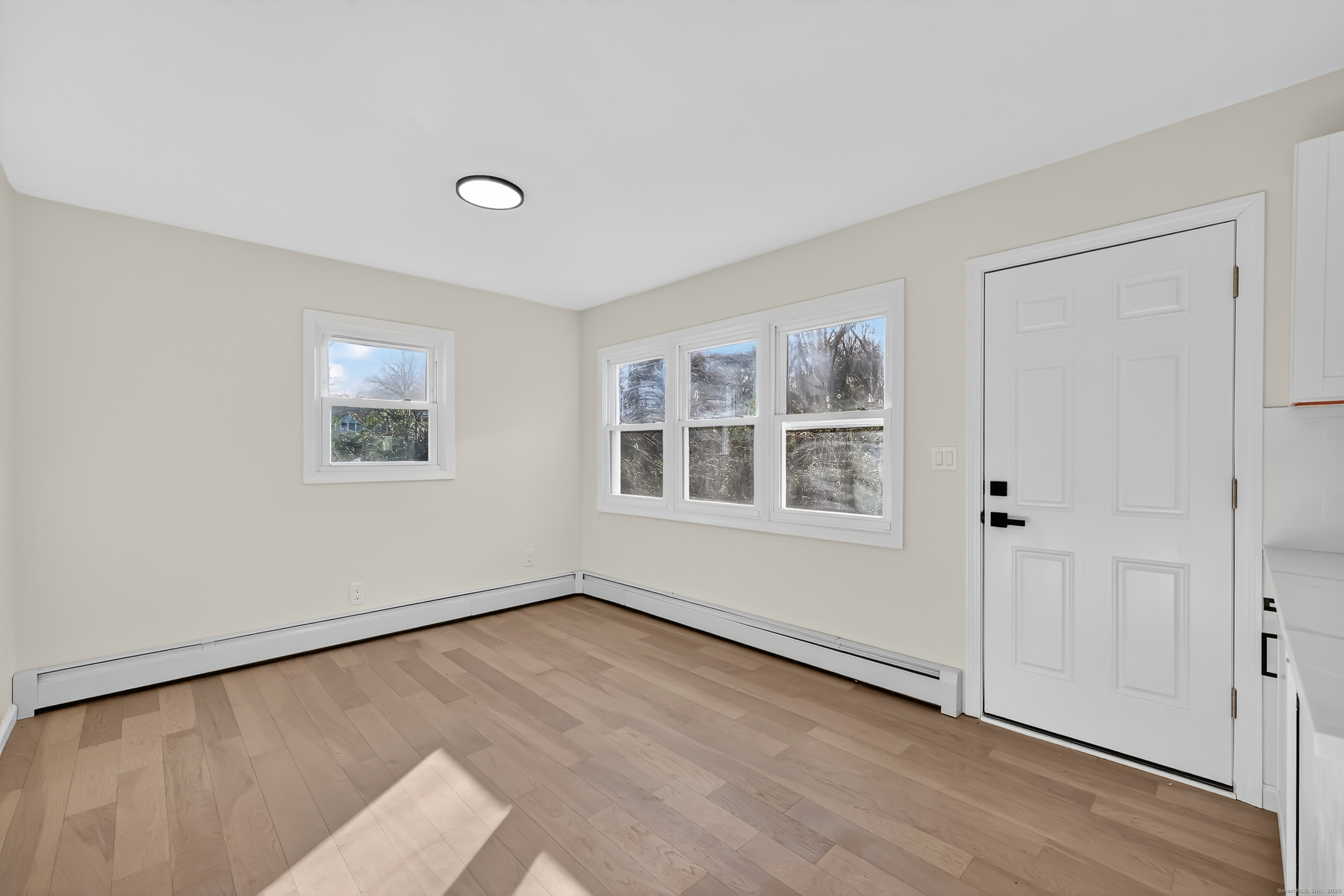 2064 Long Hill Road Guilford, CT 06437 - Photo 12 of 28 a view of an empty room with a window and wooden floor