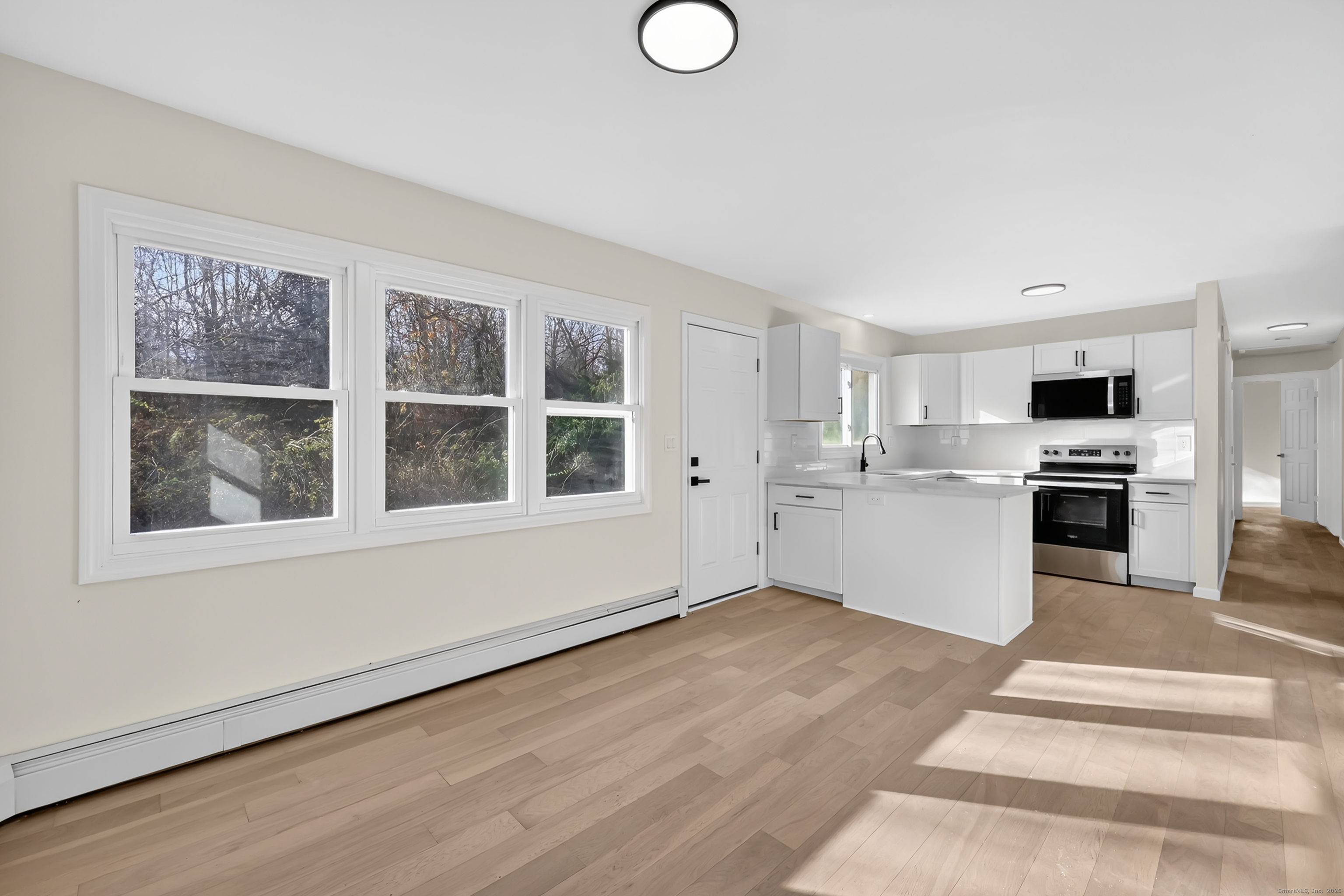 2064 Long Hill Road Guilford, CT 06437 - Photo 13 of 28 a view of a kitchen with wooden floor and windows