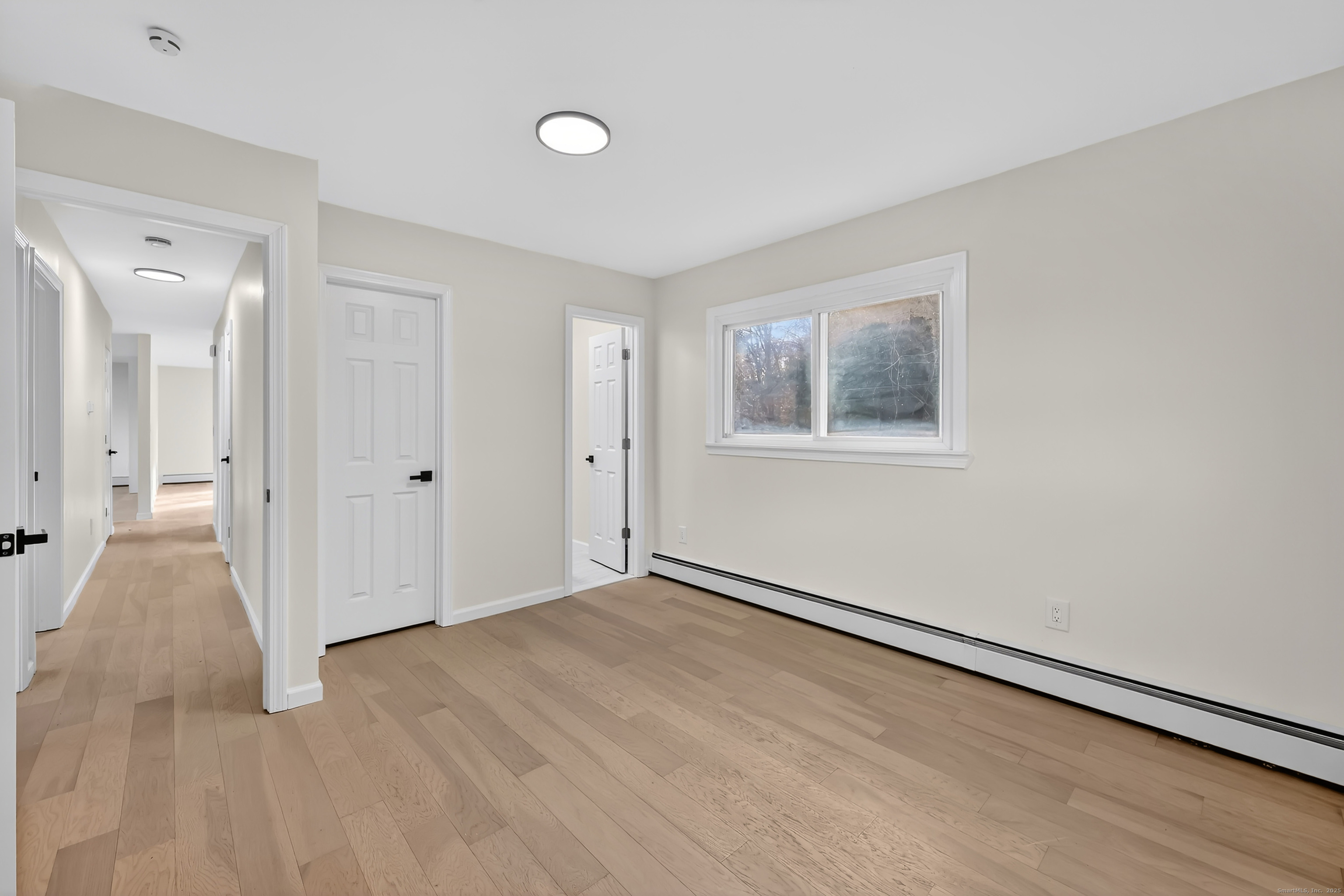 2064 Long Hill Road Guilford, CT 06437 - Photo 18 of 28 a view of an empty room with wooden floor and a window