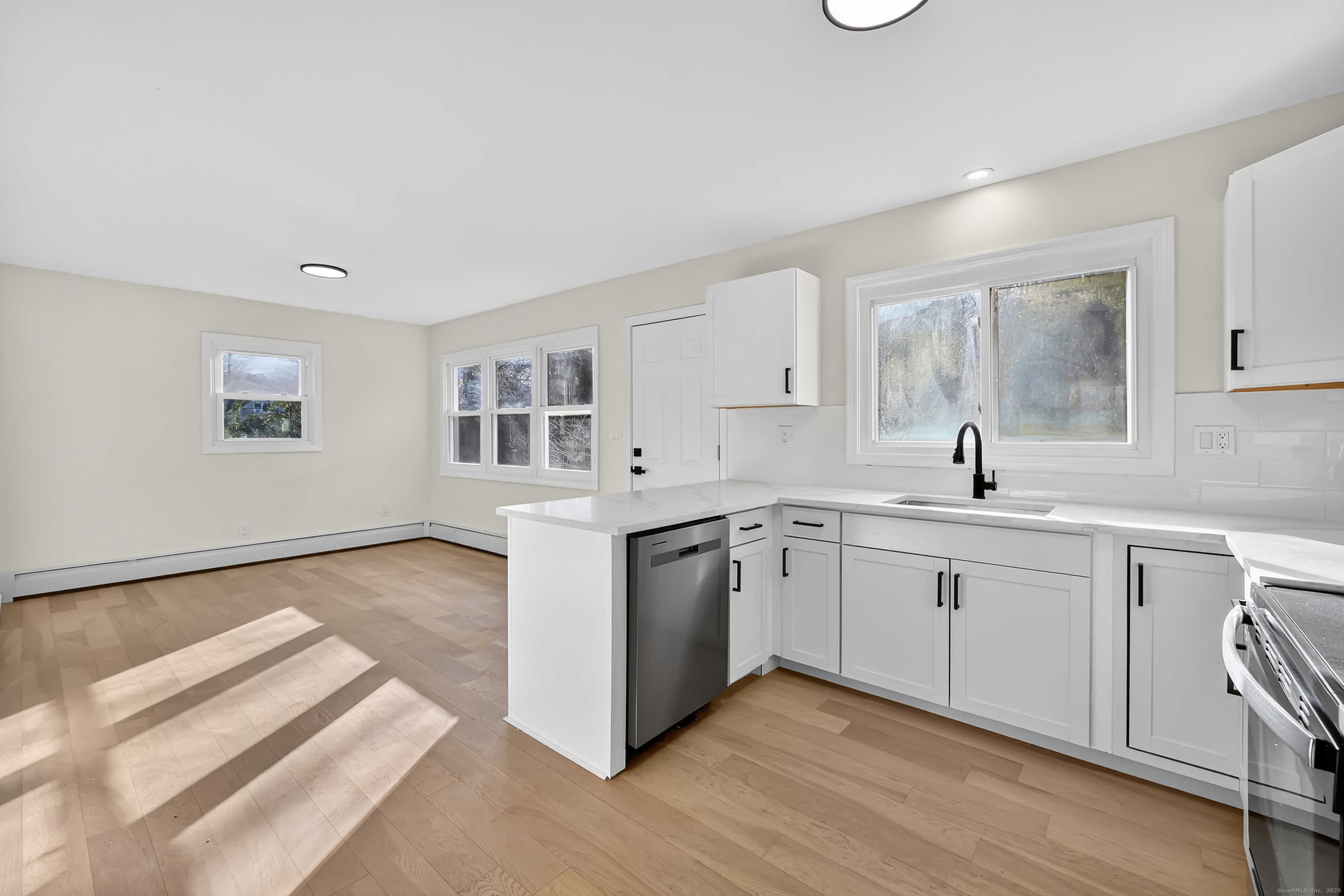 2064 Long Hill Road Guilford, CT 06437 - Photo 2 of 28 a kitchen with stainless steel appliances granite countertop a sink and cabinets with wooden floor