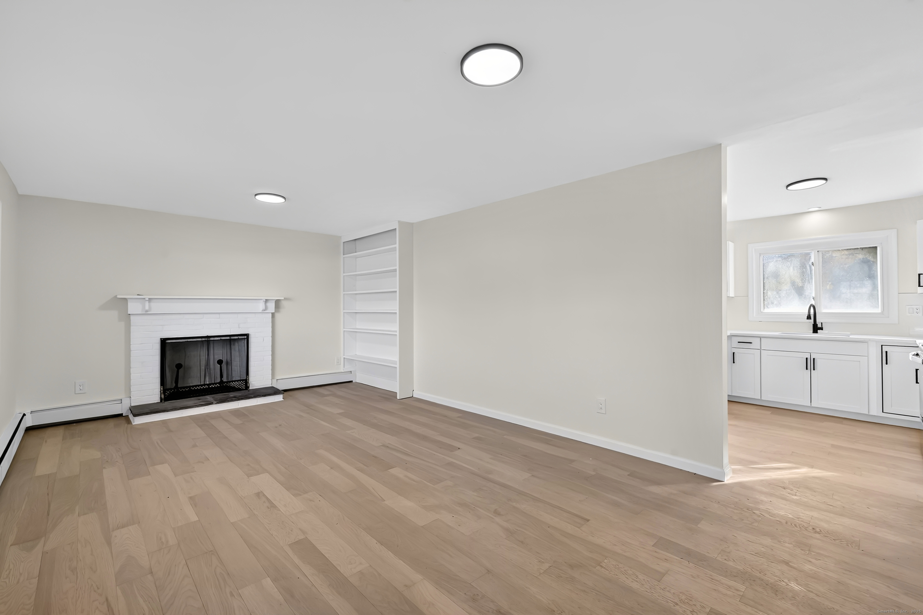 2064 Long Hill Road Guilford, CT 06437 - Photo 5 of 28 a view of an empty room with a fireplace and a window