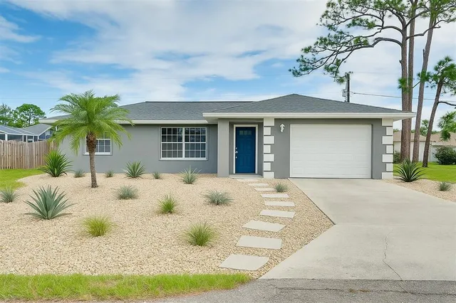 a front view of a house with a yard and a garage