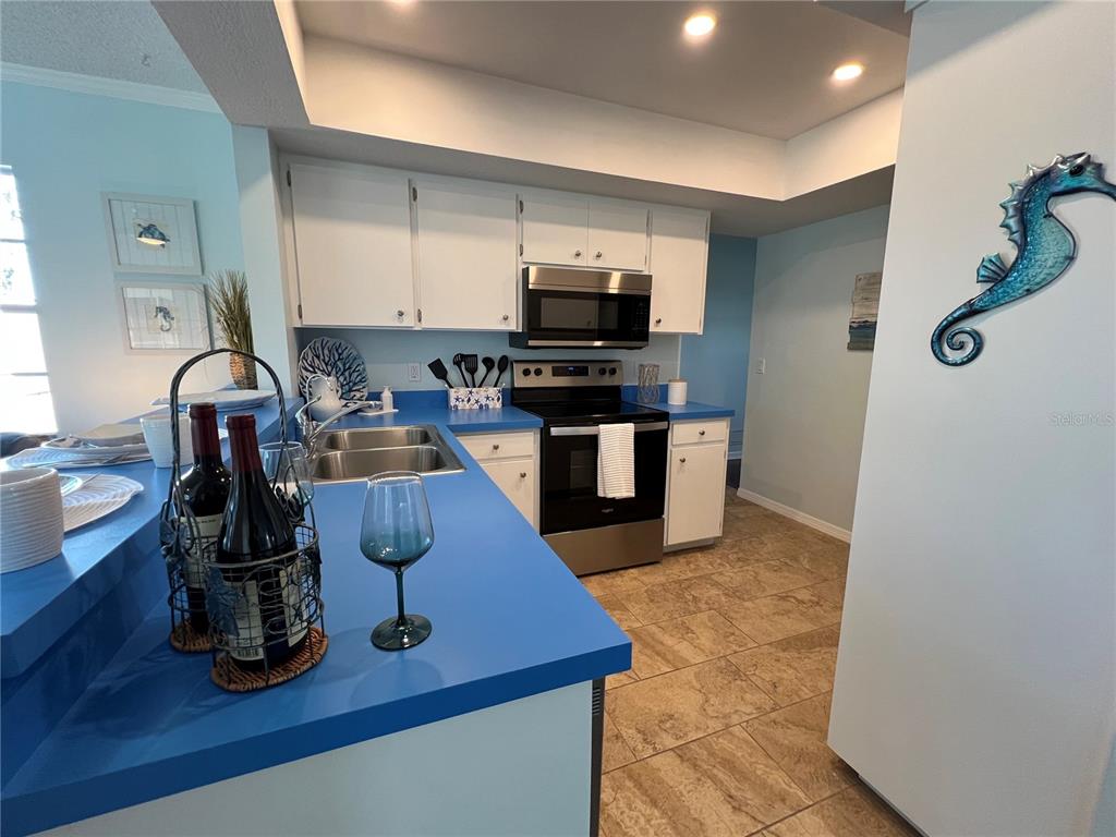 1536 Porpoise Road Venice, FL 34293 - Photo 16 of 32 a kitchen with kitchen island granite countertop a sink appliances and cabinets