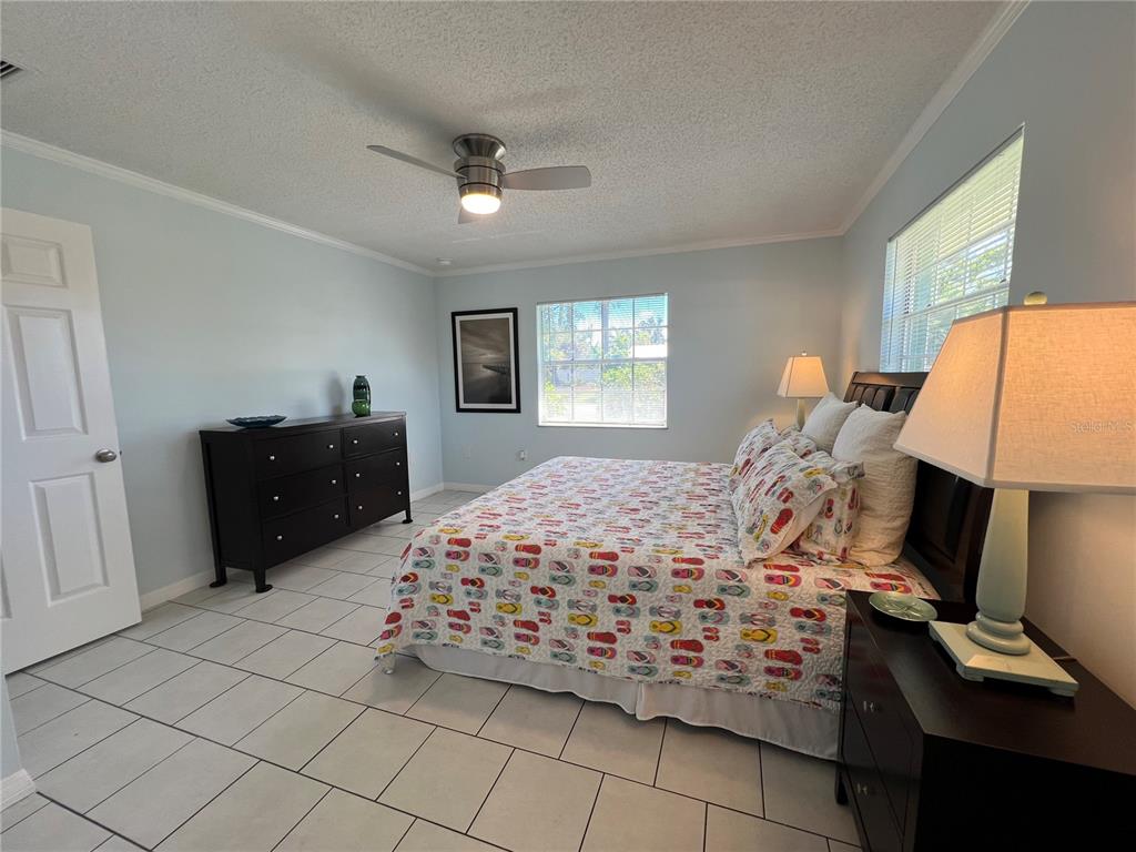 1536 Porpoise Road Venice, FL 34293 - Photo 21 of 32 a bedroom with a bed and a lamp on dresser