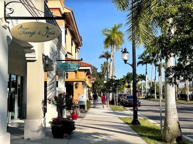 a view of path along with building and cars parked on street side