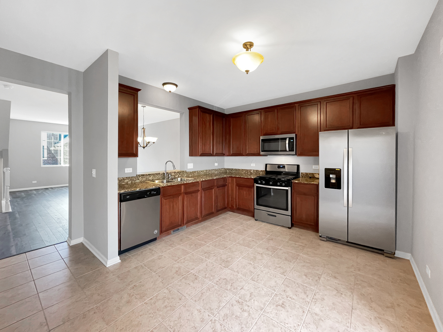3414 Cameron Drive Elgin, IL 60124 - Photo 9 of 24 a kitchen with granite countertop a refrigerator and a stove top oven