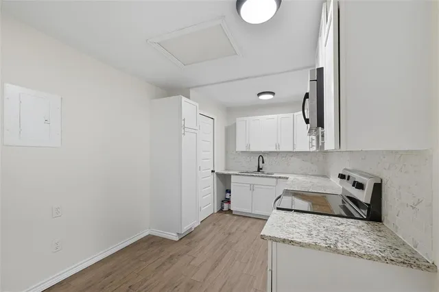 a kitchen with a sink cabinets and wooden floor