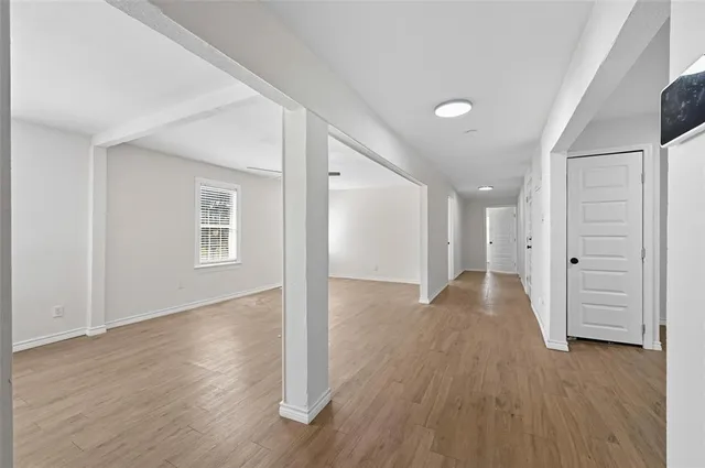 a view of empty room with wooden floor and ceiling fan