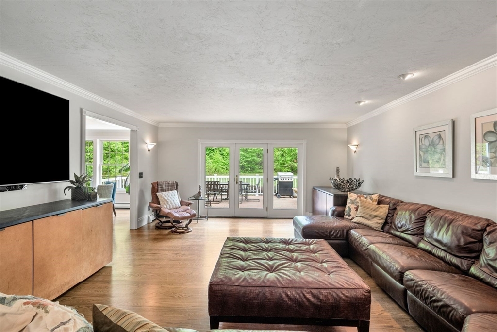 176 Spring Street Hopkinton, MA 01748 - Photo 20 of 42 a living room with a couch a large window and a flat screen tv