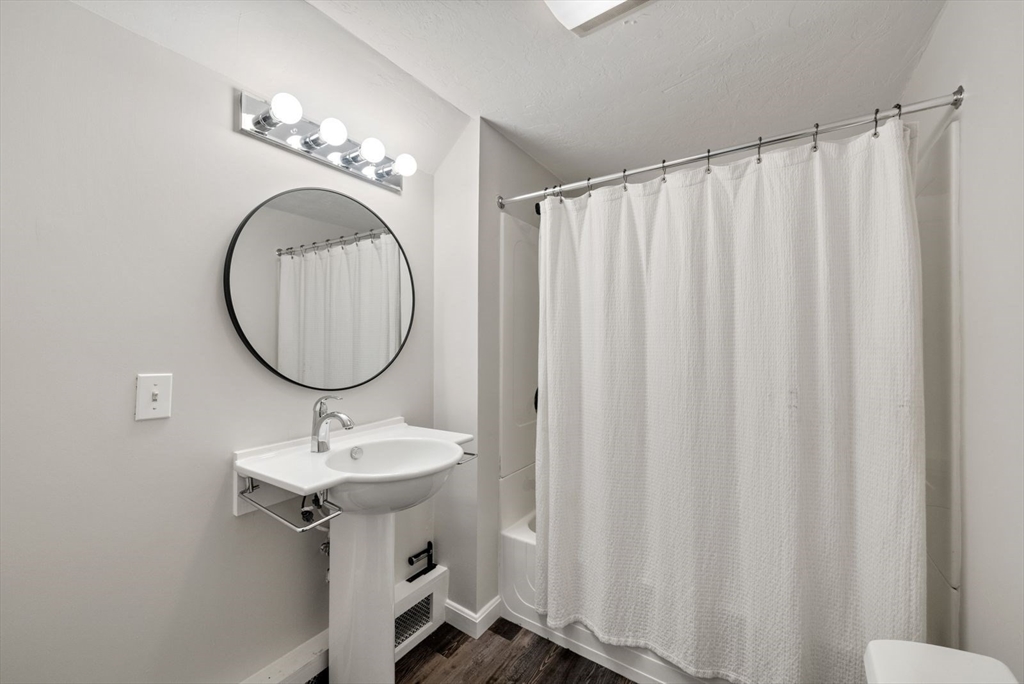 176 Spring Street Hopkinton, MA 01748 - Photo 33 of 42 a bathroom with a sink a mirror and a toilet